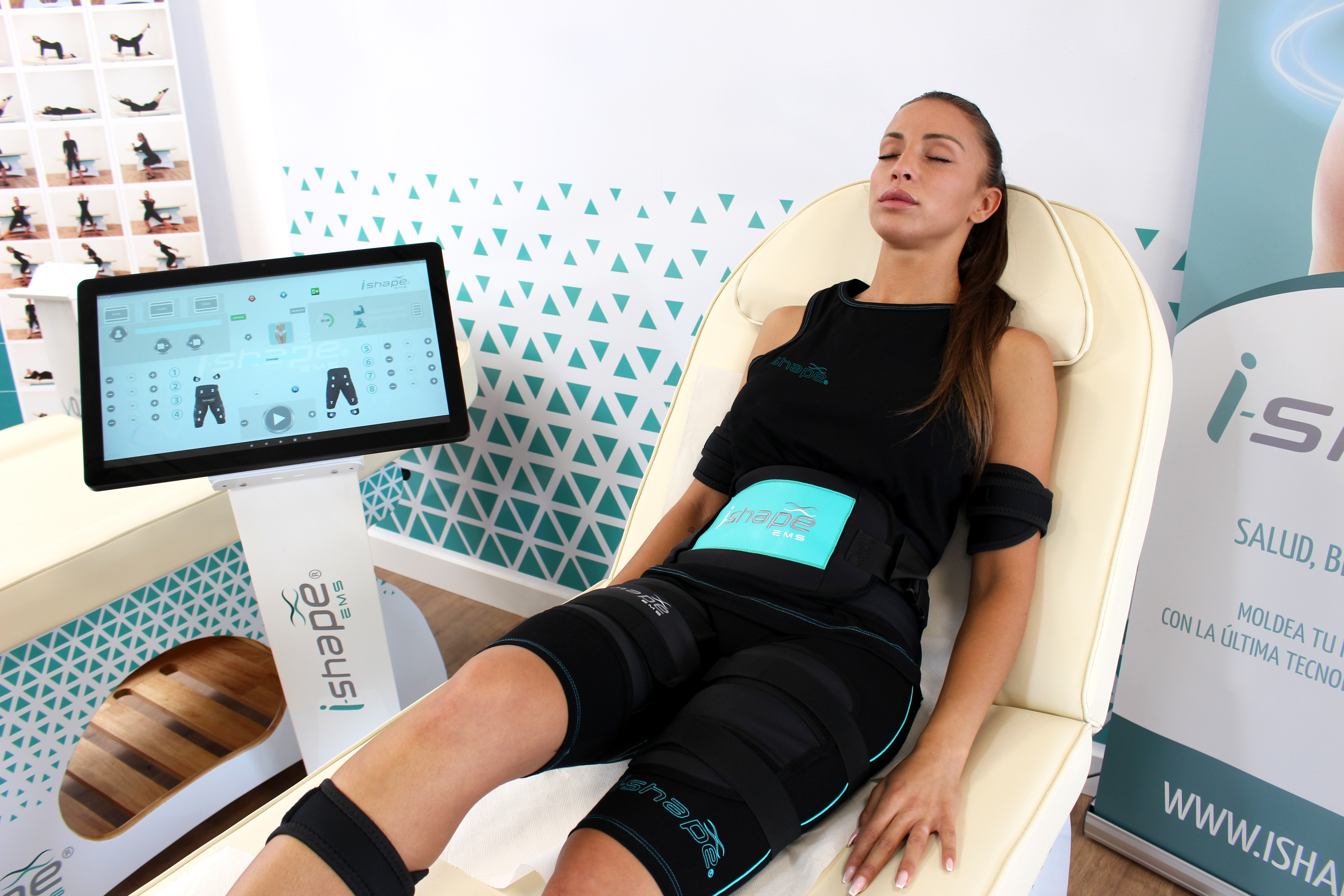 i-shape-1 Γυναίκα φορά ειδική στολή i-Shape EMS και ξαπλώνει σε κλινοειδή κάθισμα κατά τη διάρκεια συνεδρίας ηλεκτρομυοδιέγερσης στο Mark's Ground. Woman wearing i-Shape EMS suit lying on a treatment chair during an electromyostimulation session at Mark's Ground